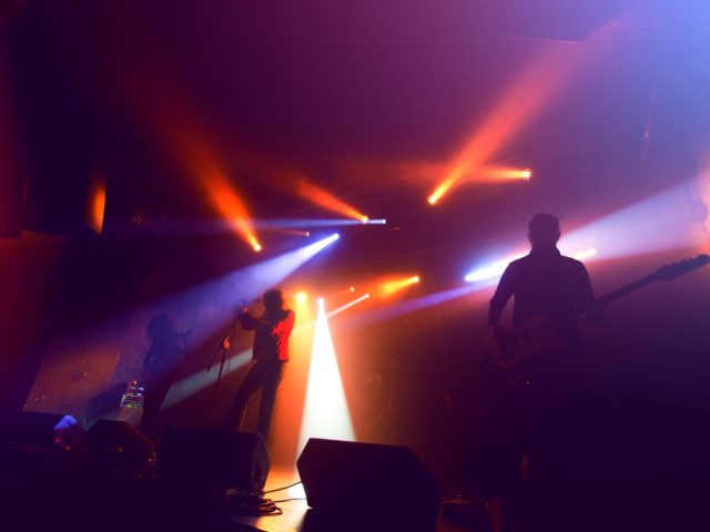 Rock band silhouettes on stage at concert. Abstract image.